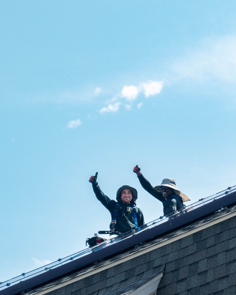 BHS crew celebrating a finished solar installation on a roof
