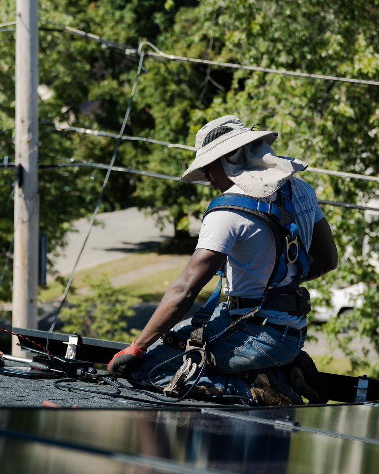 BHS installer securing a solar panel on a Massachusetts roof