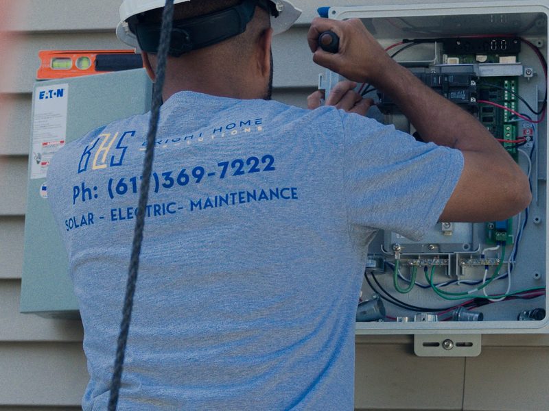BHS technician upgrading a home electrical panel during a heat pump conversion